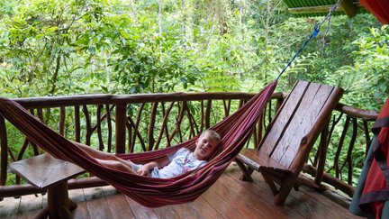 Kind liegt gemütlich in Hängematte im Baumhaus in La Tigra – Costa Rica Reise mit Kindern