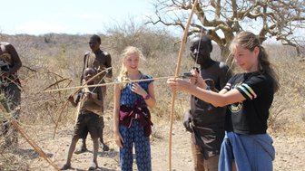 Jugendliche des Hadzabe-Stamms übt Bogenschießen – Tansania mit Kindern