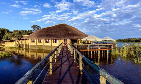 Lodge mit Reetdach, direkt am Wasser gelegen, mit Steg und Terrasse über dem Fluss - Namibia Familienreise