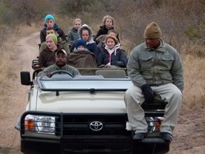 Offener Jeep mit neugieriger Reisegruppe auf Pirschfahrt durch die südafrikanische Wildnis – Südafrika Familienreise