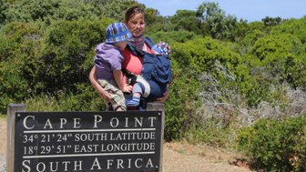 Mutter mit ihren Kindern hinter dem berühmten Holzschild am Kap der Guten Hoffnung – Familienreise Garden Route