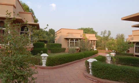 Eine malerische Resort-Anlage mit eleganten Bungalows, umgeben von üppigem Grün und gepflegten Gärten.