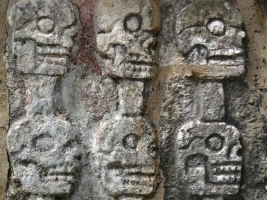 Detail einer antiken Steingravur mit Totenkopfmotiven am Tempel von Kukulcán – Mexiko Reise mit Kindern