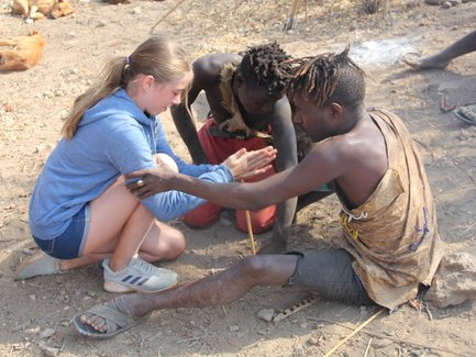 Besucherin übt das Feuer machen mit dem Hadzabe-Stamm – Tansania Familienreise