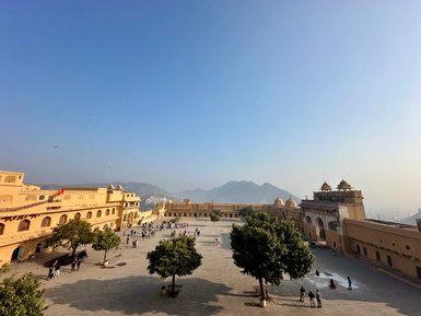 Die beeindruckende Amber-Festung in Jaipur, umgeben von sanften Hügeln und einem klaren blauen Himmel.