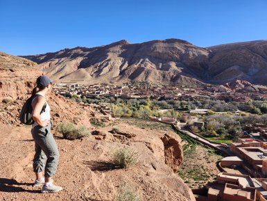 Frau betrachtet die malerische Dorflandschaft im Tal der Rosen – Marokko Familienreise