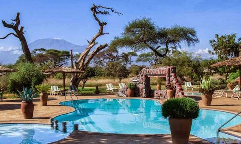 Ein einladender Pool in der Kenia-Amboseli-Region, umgeben von üppiger Vegetation und Blick auf den majestätischen Kilimandscharo.