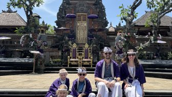 Familie in balinesischer Kleidung besucht den Pura Taman Saraswati Tempel – Bali mit Kindern