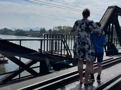 Frau und Kind blicken von Brücke auf den River Kwai - Thailand Familienreise