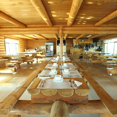 Ein geräumiges Restaurant mit Holztischen und Stühlen, das eine einladende Atmosphäre ausstrahlt.