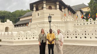 Reiseleiter und Frauen posieren gemeinsam vor dem Zahntempel in Kandy – Sri Lanka Familienreise