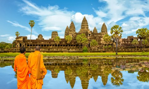Mönche gehen neben See und Tempel bei Angkor Wat – Kambodscha Familienreise