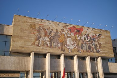 Ein großes Mosaik an der Wand zeigt eine Gruppe von Menschen in historischen Kostümen, die stolz eine Flagge halten.
