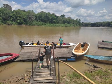 Vater und Kind gehen gemeinsam zum Boot am Flussufer des Kinabatangan – Malaysia & Borneo Familienreise