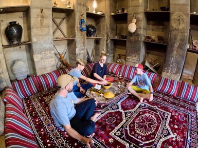 Familie sitzt auf dem Boden im Bait al Safah Museum in Al Hamra – Oman mit Kindern