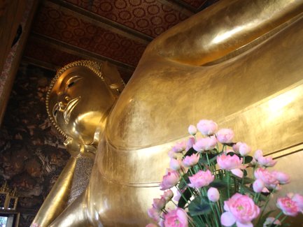 Großer liegender Buddha im Wat Pho Tempel umgeben von Blumen – Thailand Familienreise