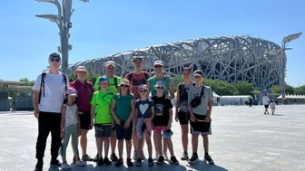 Reisegruppe macht ein Erinnerungsfoto vor dem berühmten Nationalstadion in Peking – China mit Kindern
