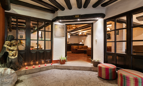 Der Eingangsbereich eines gemütlichen Lokals mit Holzdekor und einer einladenden Atmosphäre, umgeben von Kerzenlicht.