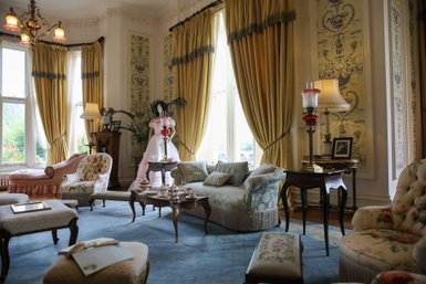 Der elegante Zeichensaal von Kylemore Abbey zeigt opulente Möbel und eine stilvolle Atmosphäre mit goldenen Vorhängen.