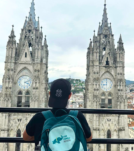Ein junger Mann mit einem schwarzen Hut blickt auf die beeindruckenden Türme einer Kathedrale in der Stadt.