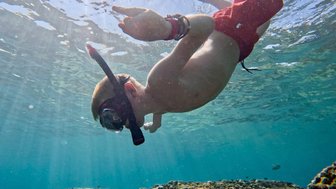 Kind schnorchelt unter Wasser an den Daymaniyat Inseln – Oman mit Kindern