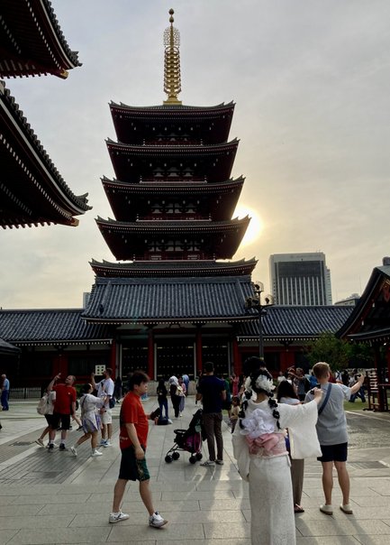 Die beeindruckende fünfstöckige Pagode erhebt sich majestätisch vor einem hellen Himmel, während Menschen um sie herum flanieren.