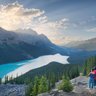 Ein Paar und ein Kind stehen auf einem Aussichtspunkt und bewundern die atemberaubende Landschaft des Icefield Parkway.