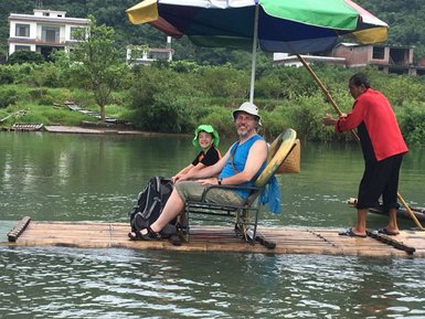 Vater und Kind genießen die Bambusfloßfahrt auf dem Yulong-Fluss – China mit Kindern