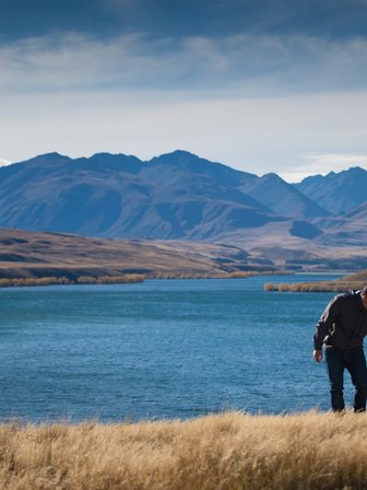 Eine Familie genießt einen sonnigen Tag am Wasser, während die Berge im Hintergrund majestätisch aufragen.
