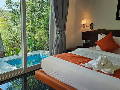 Ein elegantes Zimmer mit einem großen Fenster, das auf einen privaten Pool und üppige grüne Bäume blickt.