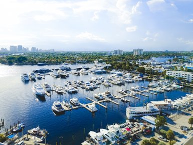 Eine Luftaufnahme eines geschäftigen Yachthafens in Fort Lauderdale, umgeben von modernen Gebäuden und üppiger Vegetation.