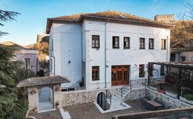 Das elegante Hotel Bineri in Gjirokaster zeigt eine moderne Fassade mit Holzfenstern und einem einladenden Eingangsbereich.