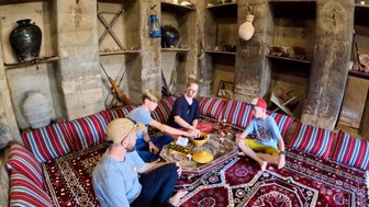 Familie sitzt auf dem Boden im Bait al Safah Museum in Al Hamra – Oman mit Kindern