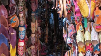 Bunte Lederschuhe auf einem Marktstand im Bazar von Marrakesch – Marokko Familienreise
