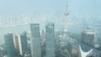 Ein Blick auf die Skyline von Shanghai, mit dem markanten Oriental Pearl Tower im Vordergrund und modernen Wolkenkratzern.