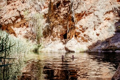 Zwei Teens schwimmen gemeinsam in einem natürlichen Pool - Namibia mit Kindern