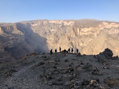 Gruppe von Reisenden nimmt die beeindruckende Naturkulisse des Jebel Shams auf – Oman mit Kindern