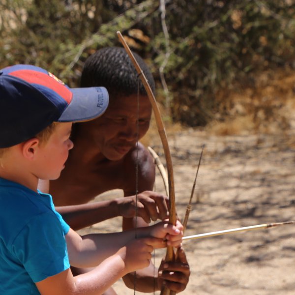Ein Kind versucht einen Bogen zu spannen - Namibia Urlaub mit Kindern
