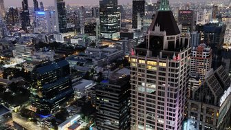 Beleuchtete Straßen und Gebäude im Herzen von Bangkok bei Nacht – Thailand mit Kindern