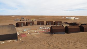 Zelte stehen im Wüstencamp unter der Sonne der Sahara – Marokko Reise mit Kindern