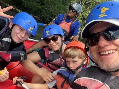 Familie und Guide posieren während Rafting-Abenteuer – Costa Rica Reise mit Kindern