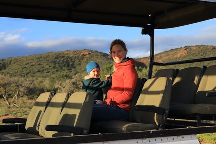 Mutter und Kind genießen gemeinsam die Safari im offenen Jeep und lächeln in die Kamera – Garden Route Reise mit Kindern