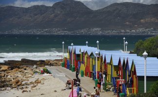 Farbenfrohe Strandhäuschen und badende Familien am St James Beach bei Kapstadt – Garden Route mit Kindern