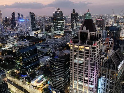 Beleuchtete Straßen und Gebäude im Herzen von Bangkok bei Nacht – Thailand mit Kindern