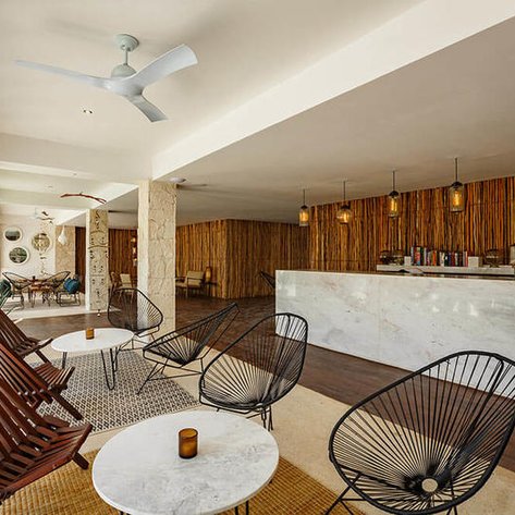 Ein stilvolles Café mit modernen Möbeln, Holzverkleidung und einer einladenden Atmosphäre, ideal für Entspannung.