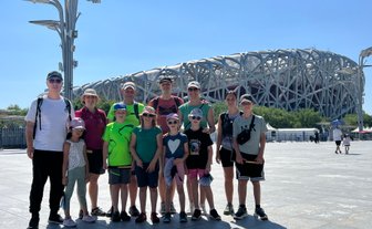 Reisegruppe macht ein Erinnerungsfoto vor dem berühmten Nationalstadion in Peking – China mit Kindern