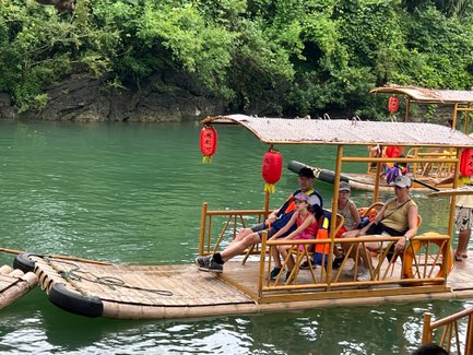 Familie gleitet entspannt auf einem traditionellen Bambusfloß über den Yulong-Fluss – China mit Kindern