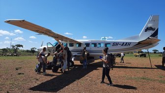 Safariflugzeug mit Reisenden in der tansanischen Landschaft – Tansania Familienreise