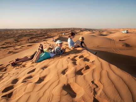 Kinder erklimmen eine hohe Düne in der Wüste Wahiba Sands – Oman mit Kindern
