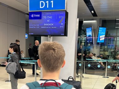 Teenager wartet am Gate auf seinen Abflug nach Bangkok – Thailand Reise mit Kindern